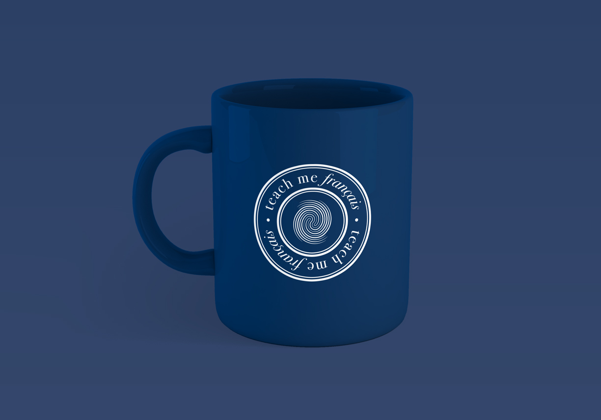 Logotipo de Teach Me Français aplicado a una taza. Logotip de Teach Me Français aplicat a una tassa.